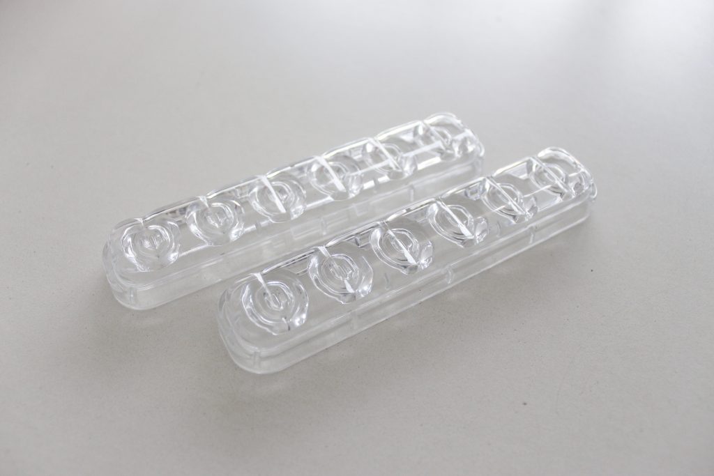 Duas peças em plástico injetado transparente.